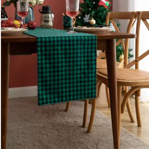Detailed texture of green and black buffalo plaid Christmas table runner on dining table
