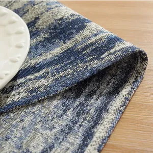 Blue gradient cotton linen placemat with geometric woven pattern on wooden table