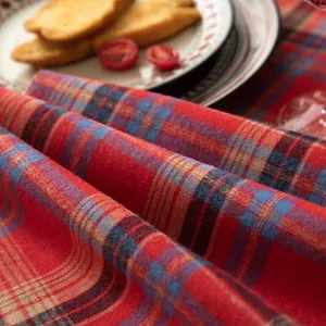 Close-up of red plaid cotton linen table runner with thick woven texture for Christmas