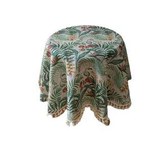 Tovaglia rotonda con stampe di piante tropicali verdi e frange su sfondo bianco