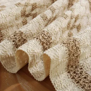 Close-up of bohemian woven table runner with beige and brown geometric hollow pattern