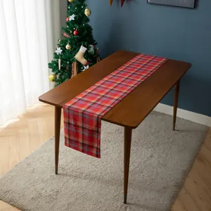 Detail shot of red and blue Christmas tartan table runner on a natural wood dining table