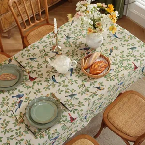Detail van jacquard tafelkleed met vintage groene planten en kleurrijke vogelmotieven
