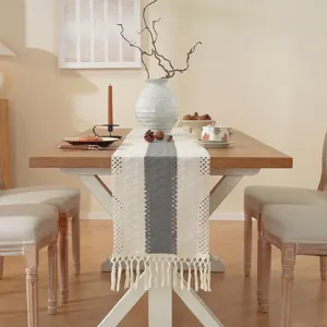 Linnen tafelloper met handgeweven middenstrip en elegante kwastjes op een houten tafel