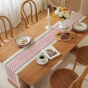 Detailed top view of cotton linen table runner with red diamond pattern and woven edges