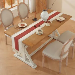 Detail van rustieke linnen tafelloper met rode strepen en franjes op houten tafel