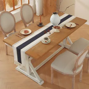 Detalle del camino de mesa nórdico con rayas azules y bordes de flecos decorativos