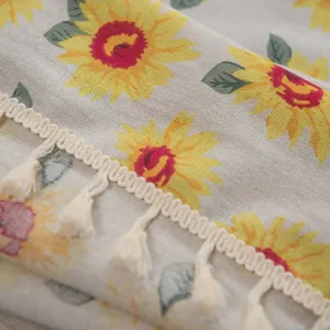 Nahaufnahme der Retro-Vorhang mit Sonnenblumenmuster und weißen Quasten am Saum