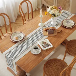 Detailed close-up of geometric diamond pattern table runner with elegant white fringe tassels