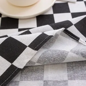 Macro shot of black and white checkered cotton linen fabric with high-density stitched edge