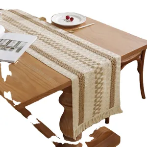 Bohemian woven table runner with geometric stripes and tassels on a wooden dining table