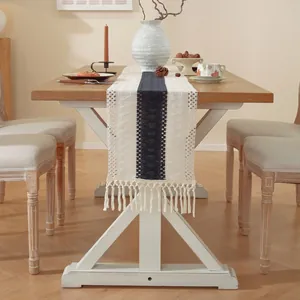 Camino de mesa tejido a mano con rayas azules y flecos sobre una mesa de comedor