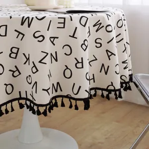 Mantel redondo de algodón y lino con estampado de letras nórdicas y borde de borlas negras