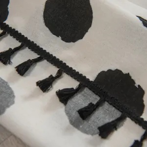 Primer plano de tela de algodón y lino con lunares negros y detalles de flecos suaves