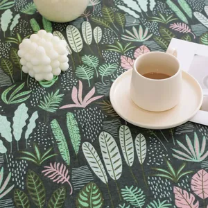 Detailed texture of dark grey linen tablecloth with colorful tropical leaf patterns