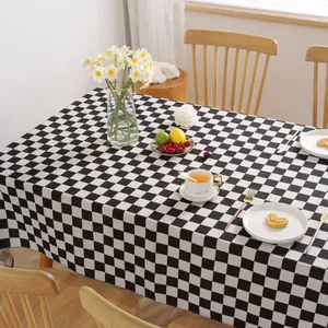 Minimalistisch zwart-wit geblokt tafelkleed op een houten eettafel in een huiselijke setting