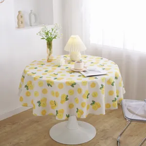 Close-up of fresh lemon print on cotton linen round tablecloth with floral decor