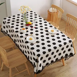 Detail der weißen Leinentischdecke mit schwarzen Punkten und dekorativen Fransen