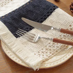 Primer plano del mantel individual tejido con textura de punto, borlas y estilo nórdico