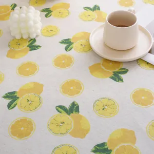 Close-up of lemon print cotton linen tablecloth with cozy home decor setting