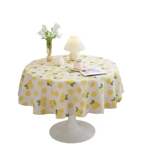 Round linen tablecloth featuring fresh lemon prints and green leaves on a white background