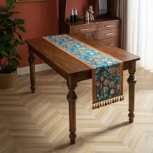 Vue détaillée du chemin de table jacquard aux motifs floraux et pompons colorés