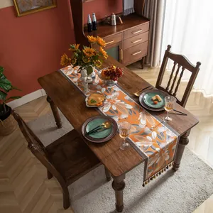Détail du chemin de table jacquard nordique avec motifs de feuilles et glands colorés