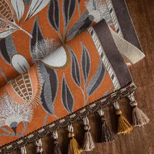 Gros plan du chemin de table jacquard avec motifs floraux vintage et détails de glands