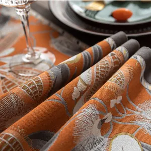 Gros plan du chemin de table en jacquard avec motif de pomme de pin orange et texture