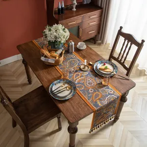 Chemin de table rétro à motif Paisley avec franges sur table en bois noir