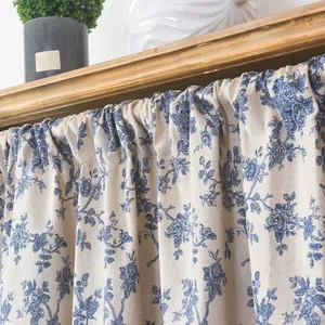 Detail of blue floral cotton linen cafe curtain with elegant rustic pleats for home