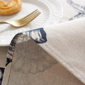 Detail of linen tablecloth featuring blue floral prints and neat edge stitching