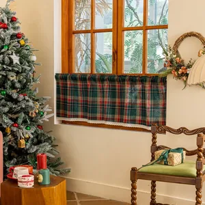 Detail of red and green plaid coffee curtain with white lace trim in a festive setting