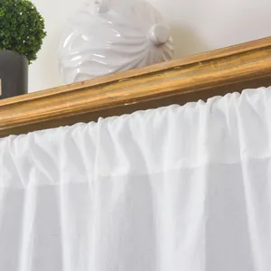 Detail of white ruffle valance with pleats on a wooden frame for a cozy kitchen