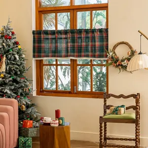 Detail of red and green plaid valance with white lace trim in a cozy Christmas setting