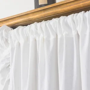 White French ruffle curtain with textured fabric shown hanging on a golden rod