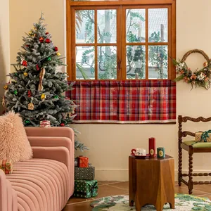 Detail of red and blue checkered cafe curtain with white lace edge in cozy holiday setting
