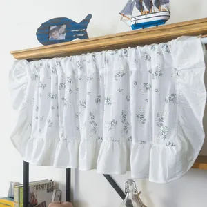 Close-up of floral cafe curtain with ruffled edges on a rustic wooden shelf decor