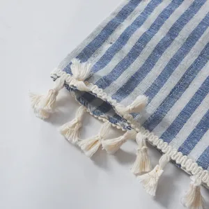 Détail d'un rideau à rayures bleu et blanc avec bordure de franges à glands blancs