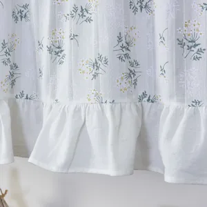 Close-up of small floral print curtains with ruffled hem and vertical woven texture