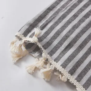 Détail macro du tissu à rayures gris et blanc avec des pompons beiges élégants