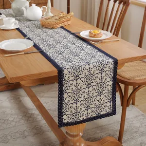 Chemin de table vintage en coton lin avec dentelle bleue sur une table en bois foncé