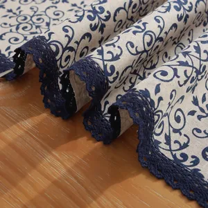 Détail d'un chemin de table en lin vintage avec fleurs bleues et dentelle sur bois