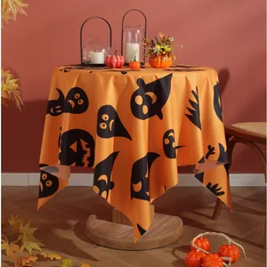Detail of orange linen Halloween tablecloth with pumpkin, ghost, and bat print patterns