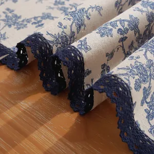 Chemin de table en coton et lin avec dentelle bleue sur fond en bois rustique