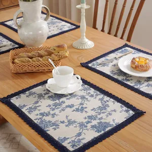 Détail d'un chemin de table floral bleu en coton et lin avec bordure en dentelle élégante