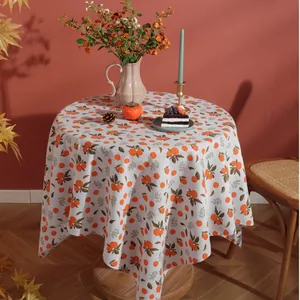 Detail of round cotton linen tablecloth with vintage orange citrus and green leaf print