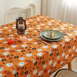Close-up of Halloween tablecloth with orange ghosts and pumpkins on a festive table
