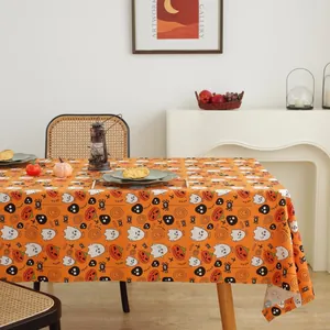 Detail of orange Halloween tablecloth with pumpkin and ghost patterns in a Nordic setting