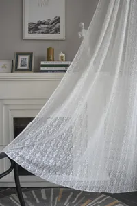 Detail of white hollow lace curtain with elegant clover flower pattern in Nordic style
